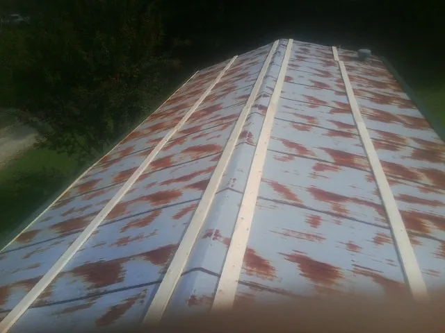 Rusted metal roof panels with new wood purlins before replacement — Storm Damage Roof Repair in Evergreen by Roofing Brothers