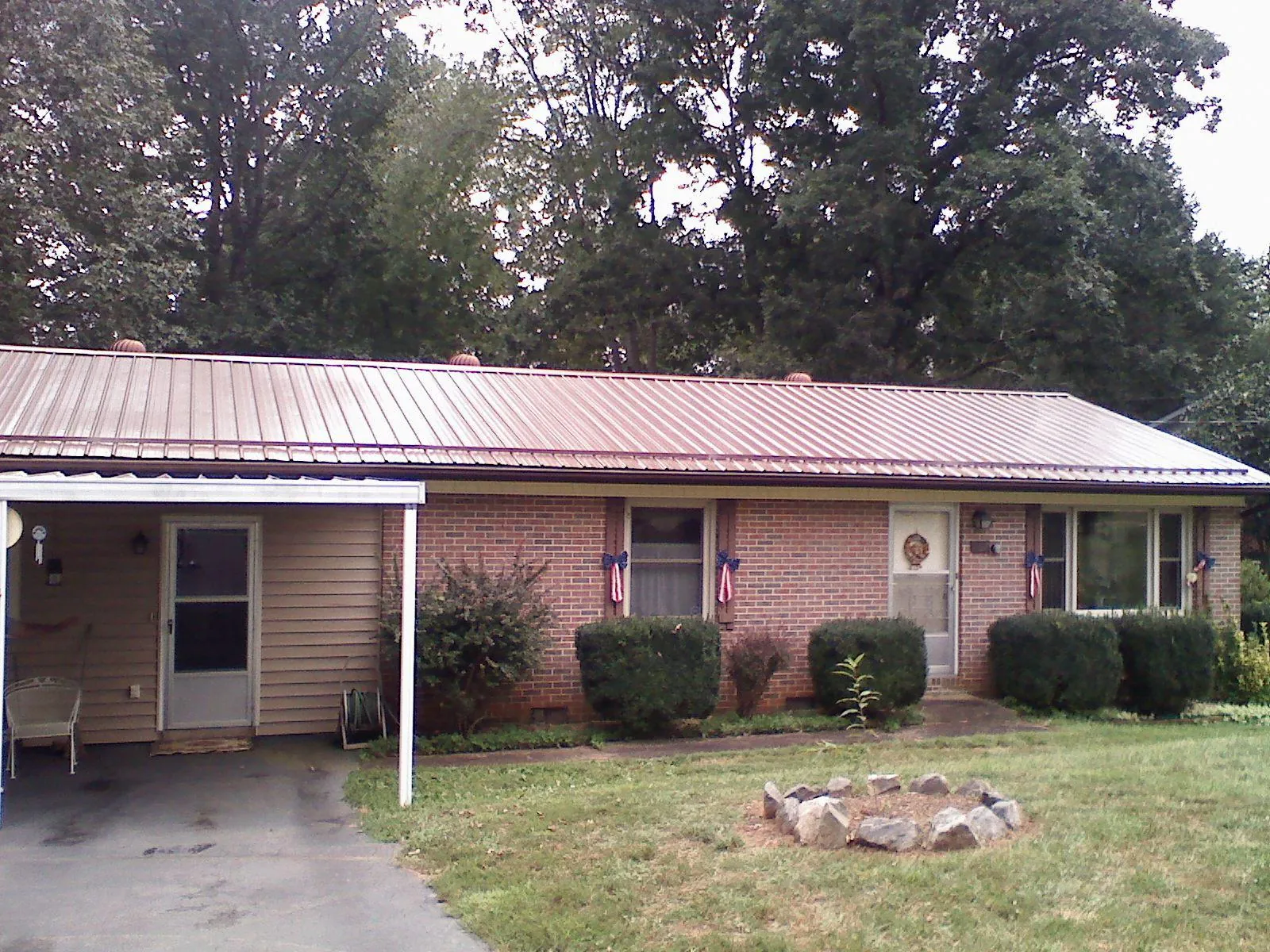 Bronze metal roof and carport on a brick ranch home — Roof Repair work by our crew in Evergreen